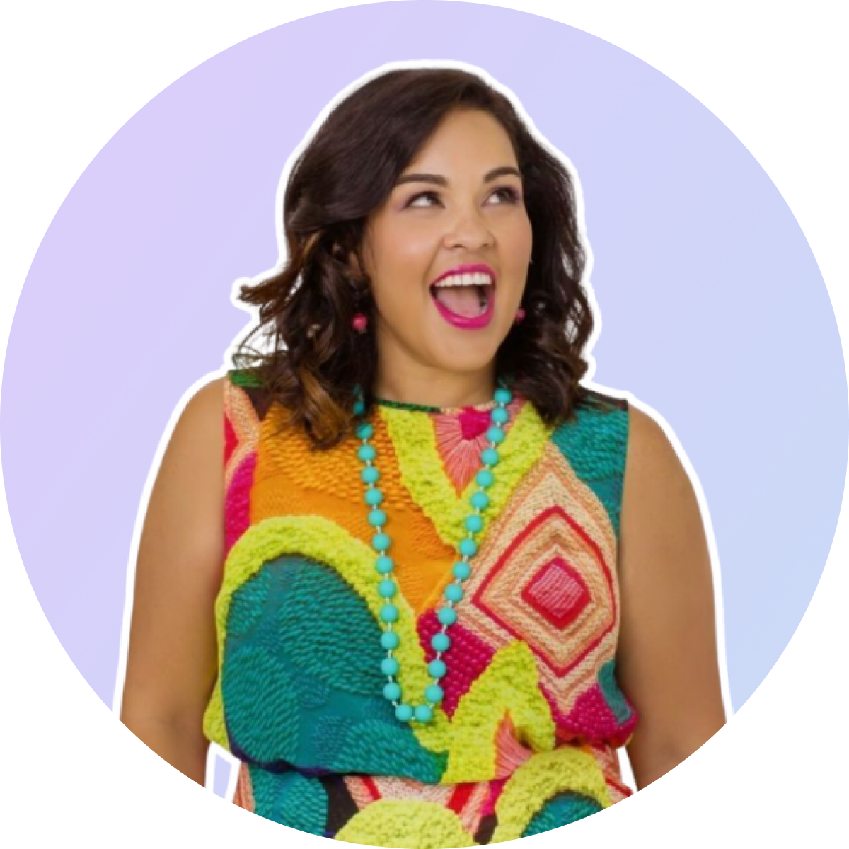 A woman with dark hair, wearing a colorful patterned dress and a turquoise necklace, smiles joyfully against a light purple background, perfect for a social media scheduler post | plannthat.com